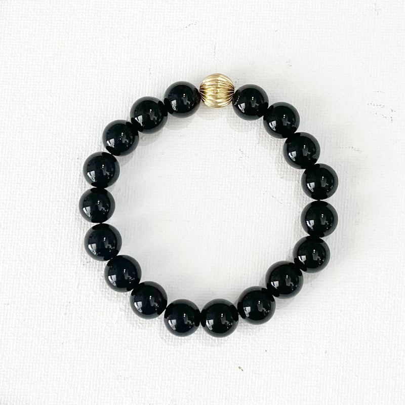Genuine 10mm black onyx beads with a gold filled accent bead. Stretch bracelet.